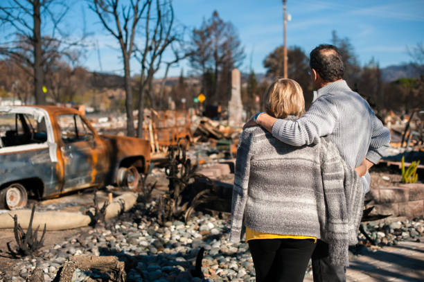 Man and his wife owners, checking burned and ruined house and yard after fire, consequences of fire disaster accident. Ruins after fire disaster.